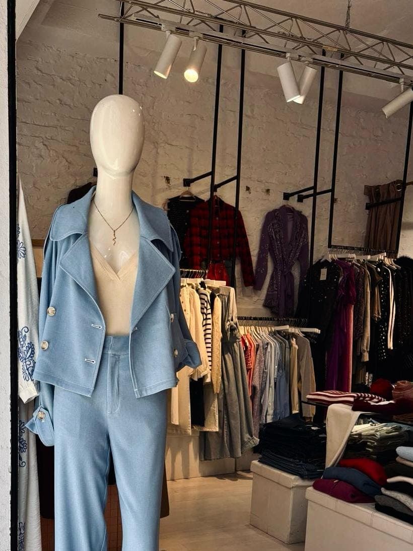 Interior de la boutique Flow, con paredes de ladrillo visto y un conjunto en azul